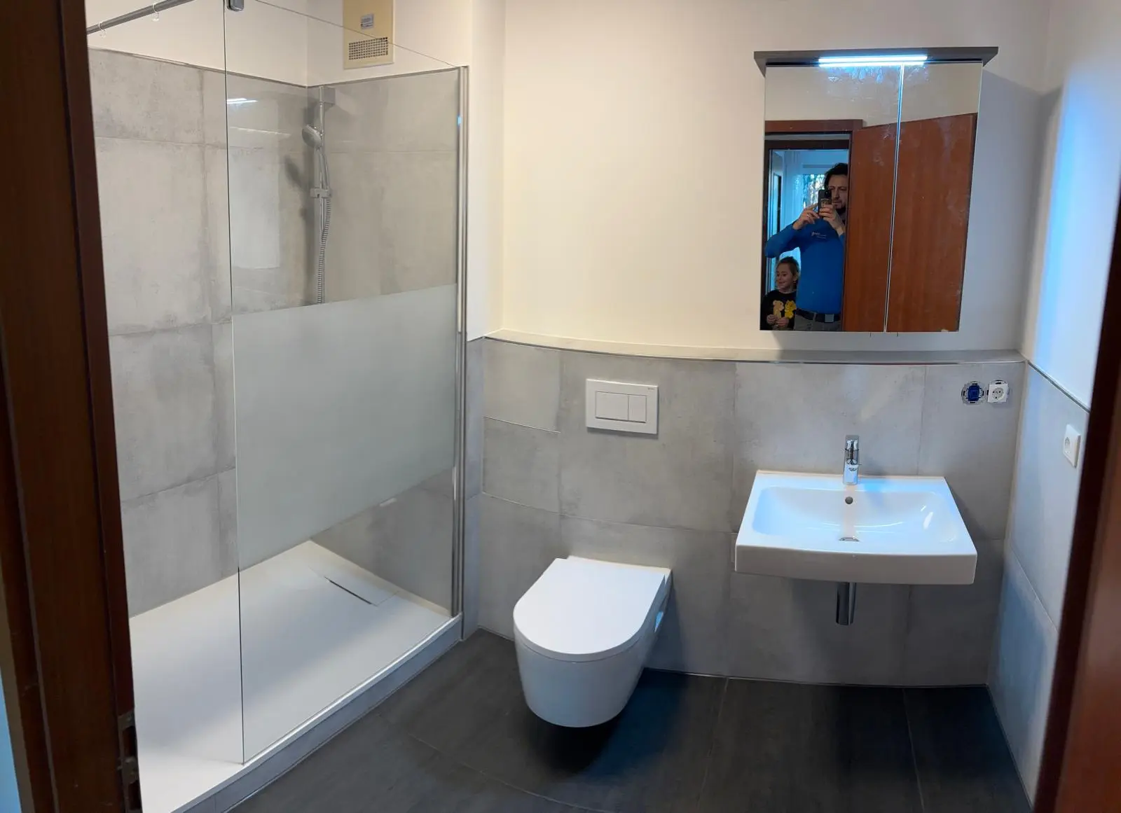 Fertiges Badezimmer: Duschkabine aus Echtglas mit mattiertem Sichtschutzstreifen und flacher Duschwanne